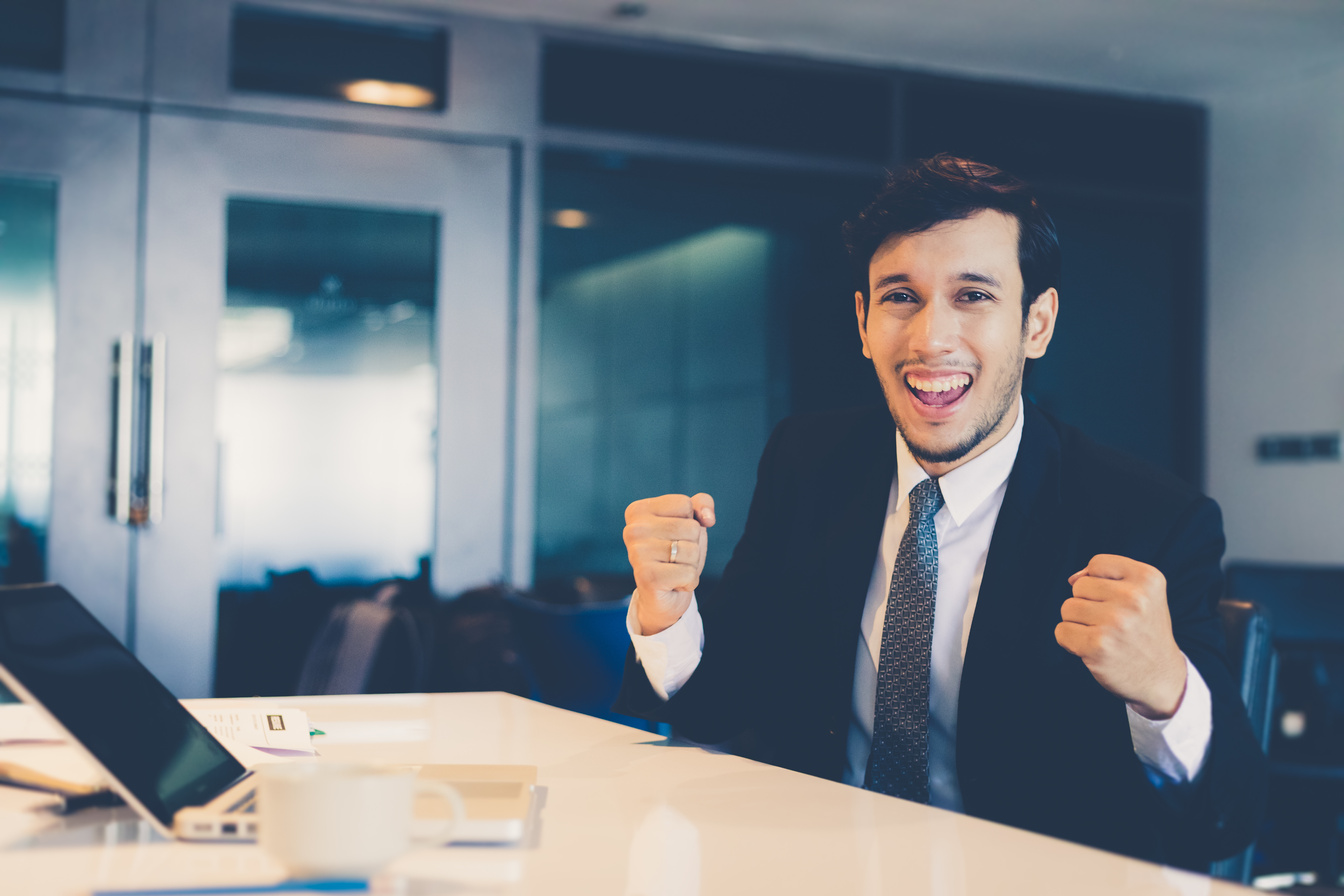 Portrait Of A Smiling Young Businessman Celebrating Success
